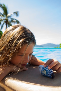 Child with souvenir poolside on Hamilton Island in the Whitsundays in the heart of Australia's Great Barrier Reef.